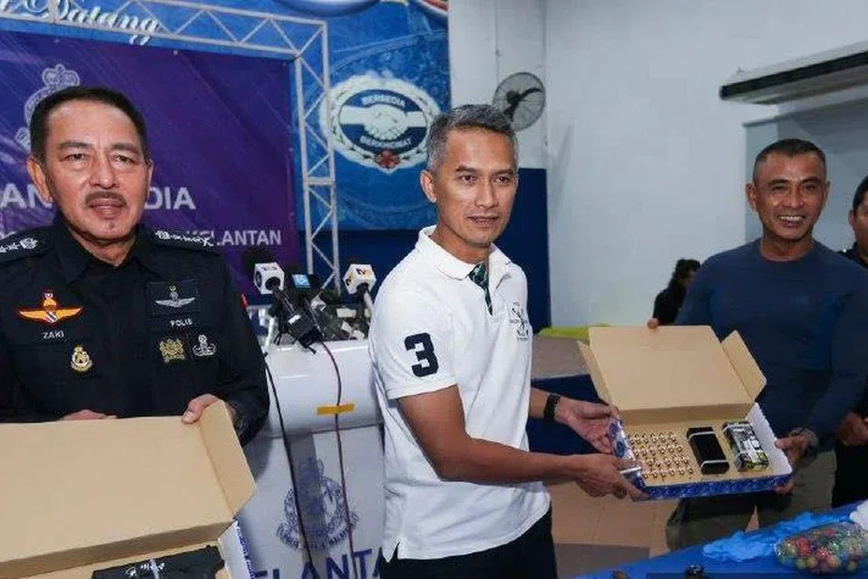 Pengarah Jabatan Siasatan Jenayah (JSJ) Bukit Aman, Datuk Seri Mohd Shuhaily Mohd Zain (tengah), bersama Ketua Polis Kelantan, Datuk Muhamad Zaki Harun (kiri), menunjukkan barang rampasan daripada suspek termasuk pistol, peluru, wang tunai baht dan riyal serta empat dokumen pengenalan diri daripada suspek kes tembakan di Lapangan Terbang Antarabangsa Kuala Lumpur (KLIA). 