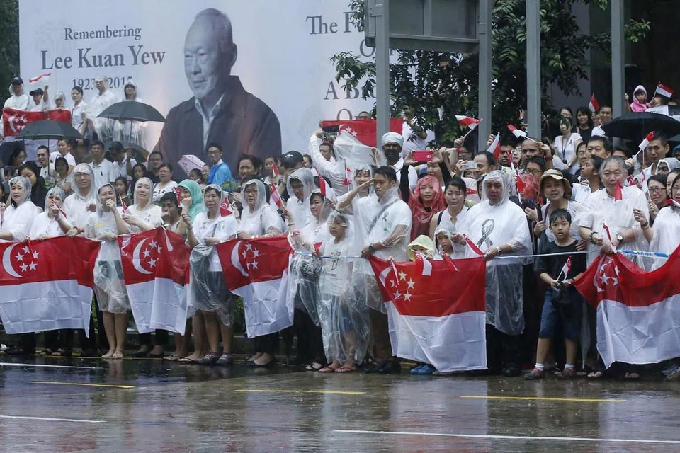 Orang ramai menunggu dalam hujan lebat di luar ibu pejabat NTUC di 1 Marina Boulevard untuk mengucapkan selamat pergi apabila kenderaan membawa mayat mendiang Perdana Menteri Pengasas Lee Kuan Yew berlalu dalam perjalanan ke upacara pembakaran mayat pada 29 Mac 2015. Twitter berkata kira-kira 1.2 juta tweet dihantar bagi memberi sokongan kepada keluarga mendiang, melahirkan kesedihan dan mengenang pencapaian beliau. 