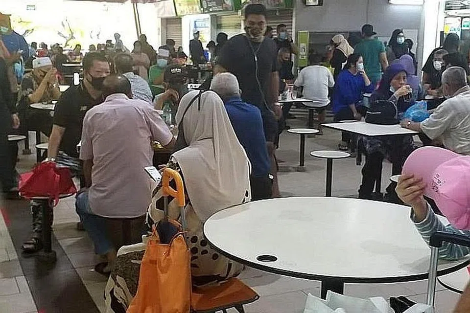 SESAK: Keadaan di Pasar Geylang Serai agak sesak pagi semalam, dengan orang ramai kelihatan menikmati sarapan mereka. - Foto PEMBACA BM.