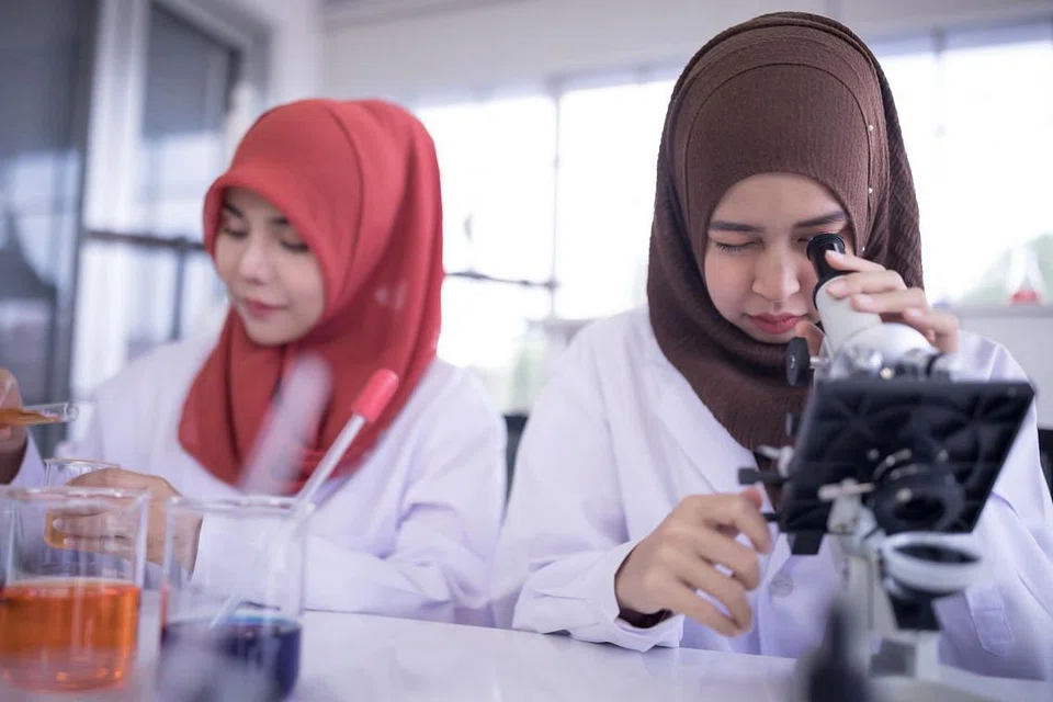 JALANKAN UJIAN: Dua kakitangan makmal sedang menggunakan mikroskop semasa menjalankan tugas di makmal. - Foto-foto ISTOCKPHOTO