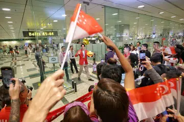  Atlet luncur lelayang, Maximilian Maeder (tengah), disambut di Terminal 3 Lapangan Terbang Changi pada 13 Ogos setelah meraih pingat gangsa dari Sukan Olimpik Paris. 