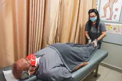 RAWAT KAKI: Encik Ahmad Ibrahim melakukan terapi urut Tuina di kakinya ketika mengunjungi Perubatan Institusi Sian Chay di Marsiling Drive untuk rawatannya. 