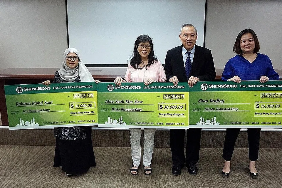 KEMENANGAN TAK DISANGKA: Cik Rohana (kiri) memenangi cabutan bertuah di tempat ketiga. Beliau bersama Cik Alice Seah Kim Siew (dua dari kiri), Ketua Pegawai Eksekutif Kumpulan Sheng Siong, Encik Lim Hock Chee (dua dari kanan) dan Cik Zhao YanJing (paling kanan). - Foto SHENG SEONG