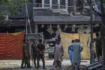 Foto Fail: Polis dan penduduk tempatan berdiri berhampiran lokasi letupan di Lahore pada 24 Jun 2021, sehari selepas sebuah kereta bom meragut tiga nyawa di bandar mega timur Pakistan itu.