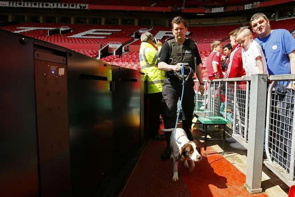 Polis menggunakan anjing pengesan sedang peminat dipindahkan dari stadium sebelum perlawanan di Old Trafford pada 15 Mei 2016. 