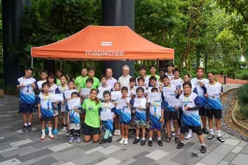 Peserta Kem Futsal Belia Mapletree bergambar bersama Pengerusi Mapletree, Encik Edmund Cheng (tengah, berkot putih), pada hari pertama kem di Mapletree Business City.  
