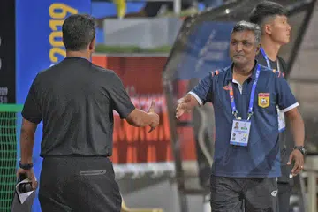 TERIKAT SERI: Fandi (kiri) dan Sundram (kanan) bersalaman selepas perlawanan antara Singapura dengan Laos berakhir 0-0. - Foto-foto BH oleh MARK CHEONG