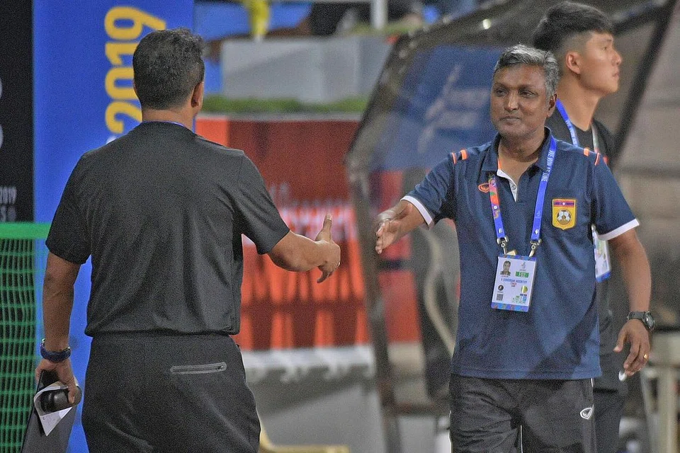 TERIKAT SERI: Fandi (kiri) dan Sundram (kanan) bersalaman selepas perlawanan antara Singapura dengan Laos berakhir 0-0. - Foto-foto BH oleh MARK CHEONG