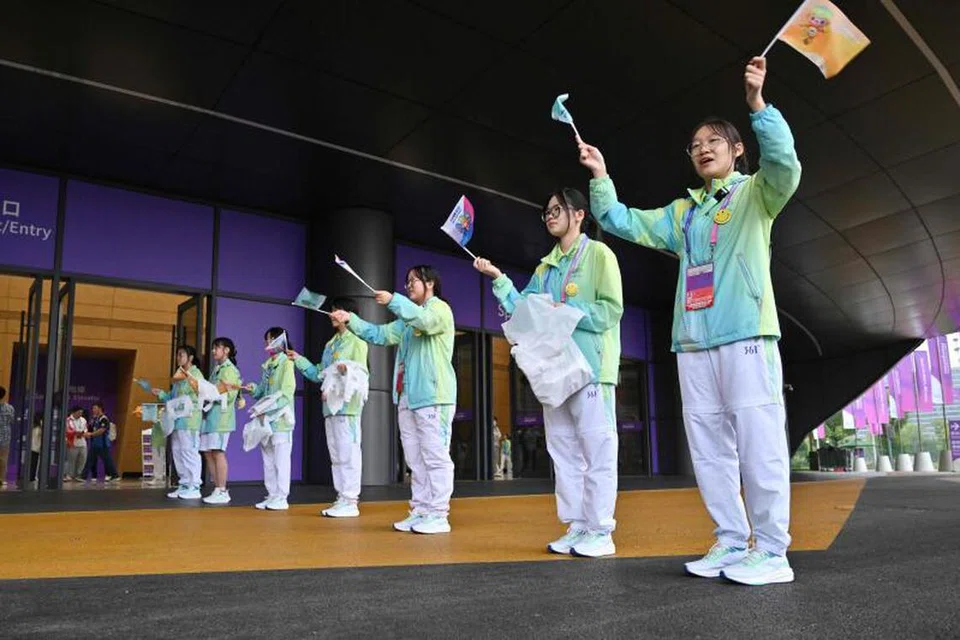 MESRA SAMBUT HADIRIN: Relawan menyambut penonton di Gimnasium Taman Sukan Terusan Gongshu semasa pusingan awal acara berpasukan tenis meja pada Jumaat.