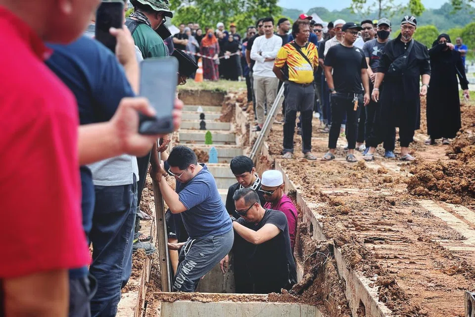 Anak sulung Allahyarham Nur Mohammad Azmi, Encik Sofyan Nur Mohammad, kelihatan memanjat tangga selepas arwah bapanya diletakkan di liang lahad.