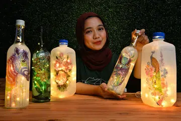 PRODUK KITAR TINGGI: Antara produk kegemaran Cik Nur Nadhirah Azman, yang bertanggungjawab untuk program latihan dan jangkauan Terra SG, adalah lampu botol yang dikitar tinggi secara kreatif, dengan menggunakan bahan botol plastik atau gelas untuk menjadi lampu. - Foto BM oleh CHONG JUN LIANG