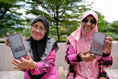 SUDAH TIDAK TERKIAL-KIAL: Cik Asmah Talib, 64 tahun (kiri) dan temannya Cik Salmabee Abdul Kadir, 66 tahun, yang telah menghadiri bengkel celik digital warga emas Jom Surf! Januari lalu, menunjukkan aplikasi HealthHub dan SingPass dalam telefon bimbit mereka. - Foto BM oleh THADDEUS ANG