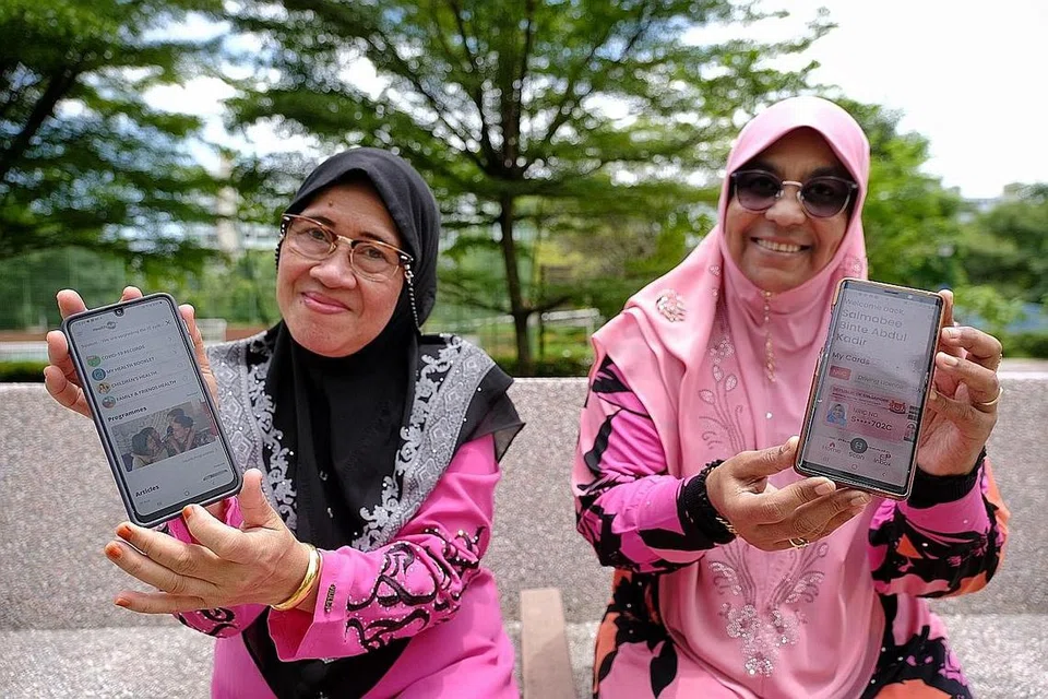 SUDAH TIDAK TERKIAL-KIAL: Cik Asmah Talib, 64 tahun (kiri) dan temannya Cik Salmabee Abdul Kadir, 66 tahun, yang telah menghadiri bengkel celik digital warga emas Jom Surf! Januari lalu, menunjukkan aplikasi HealthHub dan SingPass dalam telefon bimbit mereka. - Foto BM oleh THADDEUS ANG