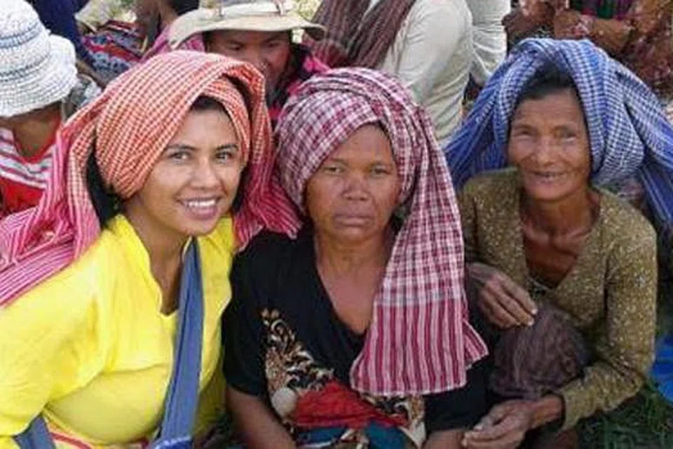BERSAMA PENDUDUK: Cik Saleemah (berbaju kuning) bersama penduduk kawasan petempatan semula Kampung Speu di Kemboja semasa Hope Villages mengadakan lawatan muhibah ke tempat itu Disember lalu. - Foto HOPE VILLAGES