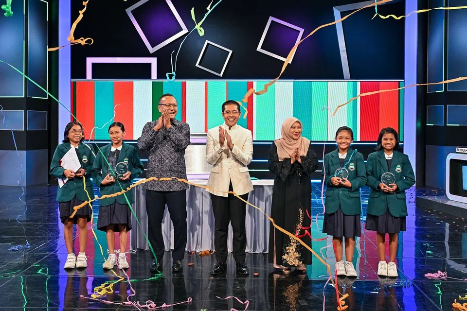 JUARA PERMAINAN TELEVISYEN: Menteri di Pejabat Perdana Menteri yang juga Menteri Kedua Pendidikan merangkap Ehwal Luar, Dr Mohamad Maliki Osman (tengah) merai kejuaraan Sekolah Rendah Perempuan Raffles dalam rancangan permainan televisyen, ‘Cepat Tepat’. Bersama Dr Maliki, yang juga pengerusi Jawatankuasa Pembelajaran dan Penggalakan Penggunaan Bahasa Melayu (MLLPC), ialah Ketua Editor Berita dan Ehwal Semasa (Melayu) Mediacorp, Encik Sujadi Siswo (tiga dari kiri); Timbalan Pengarah, Cawangan Bahasa Ibunda, Cik Salbiah Abas; dan juga peserta dari Sekolah Rendah Perempuan Raffles. 