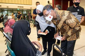 AGIH HABUAN RAMADAN: Anggota Parlimen SMC Bukit Batok, Encik Murali Pillai (kanan) dan Setiausaha Besar Persatuan Muhammadiyah, Cik Roszanah Abdul Salim (sebelah Encik Murali),  mengagihkan Habuan Ramadan di Hab Sukan Bukit Batok pada Ahad (11 April).