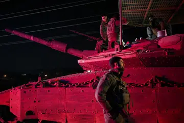 Tentera Israel berkumpul berhampiran sebuah kenderaan tentera selepas kembali dari Lebanon  susulan gencatan senjata antara Israel dengan kumpulan Hezbollah yang disokong Iran, berhampiran Kiryat Shmona dan sempadan Israel-Lebanon di utara Israel, pada 11 Disember. 