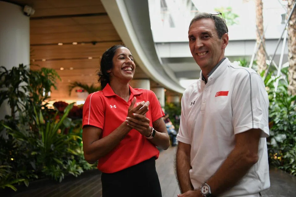 PRESTASI CEMERLANG: Ratu pecut Singapura, Shanti Pereira (kiri) bersama jurulatih Luis Cunha di Lapangan Terbang Changi setelah mendarat dari Kejuaraan Olahraga Asia di Bangkok pada 17 Julai.