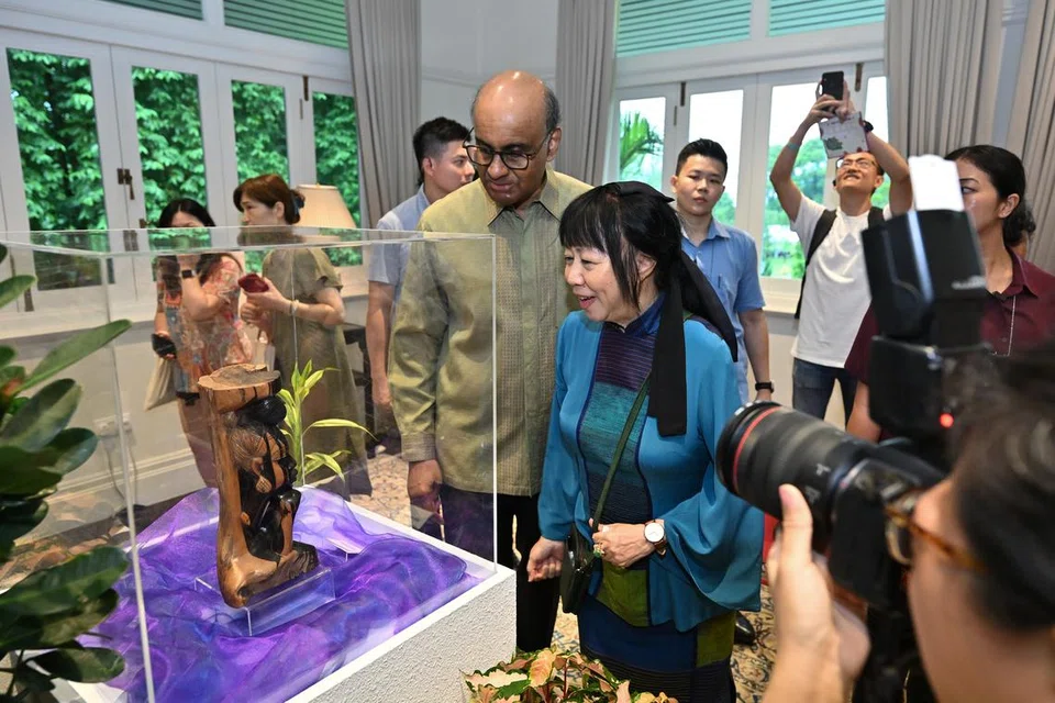 Presiden Tharman Shanmugaratnam (berkemeja hijau) dan isterinya, PuanJane Ittogi (kiri beliau) sedang meninjau Hadiah Negeri, ukiran kayu dari Côte d’Ivoire, sebuah negara di Afrika Barat