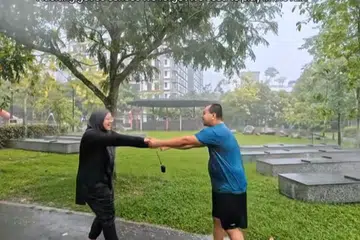 Pasangan suami isteri, Encik Adi Iskandar Osman dan Cik Nur Liyana Saripie menganggap bermain dalam hujan sebagai aktiviti untuk hilangkan tekanan.