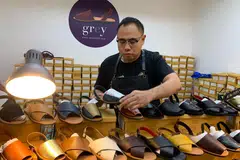 RINDU SUASANA NIAGA DI GEYLANG: Encik Trisno sedang menyusun sandal yang dijual di kedai baru yang disewa untuk jangka pendek di TKC. - Foto ihsan TRISNO ISHAK