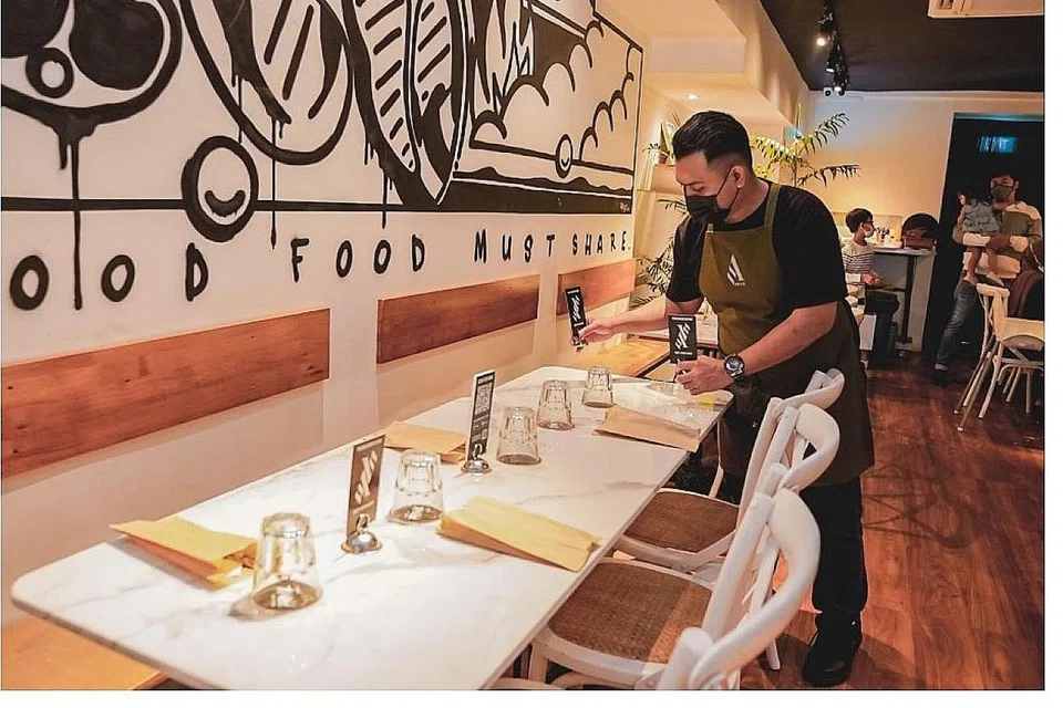 GIAT BERSIAP SEDIA: Kakitangan Asap & Co membuat persiapan dengan mengatur semula tempat duduk untuk menampung kumpulan lima orang. - Foto BH oleh NUR DIYANA TAHA