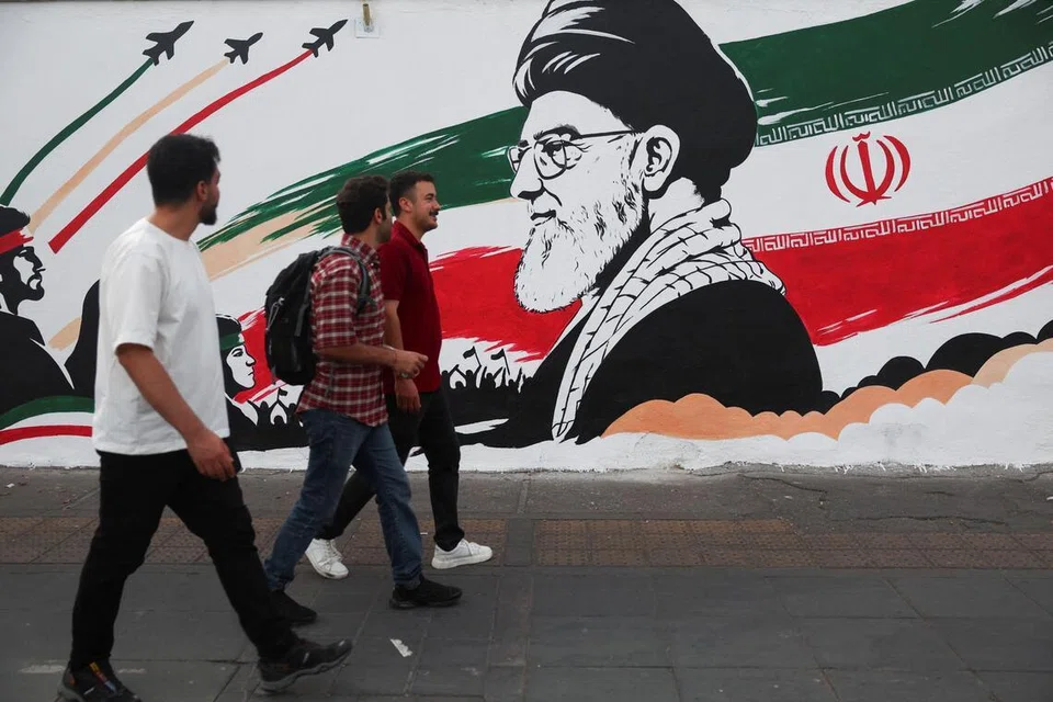 Orang ramai berjalan melewati mural memaparkan gambar bekas pemimpin tertinggi Iran, Ali Khamenei, menjelang upacara penghormatan terakhir untuk beliau di Teheran, Iran pada 1 Julai 2026.