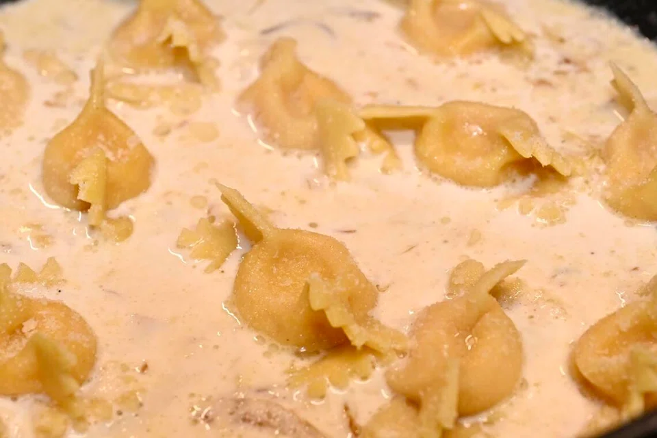 Pasta Scarpinocc diisi dengan labu panggang, dihidangkan dengan sos krim lemon dan hazelnut.