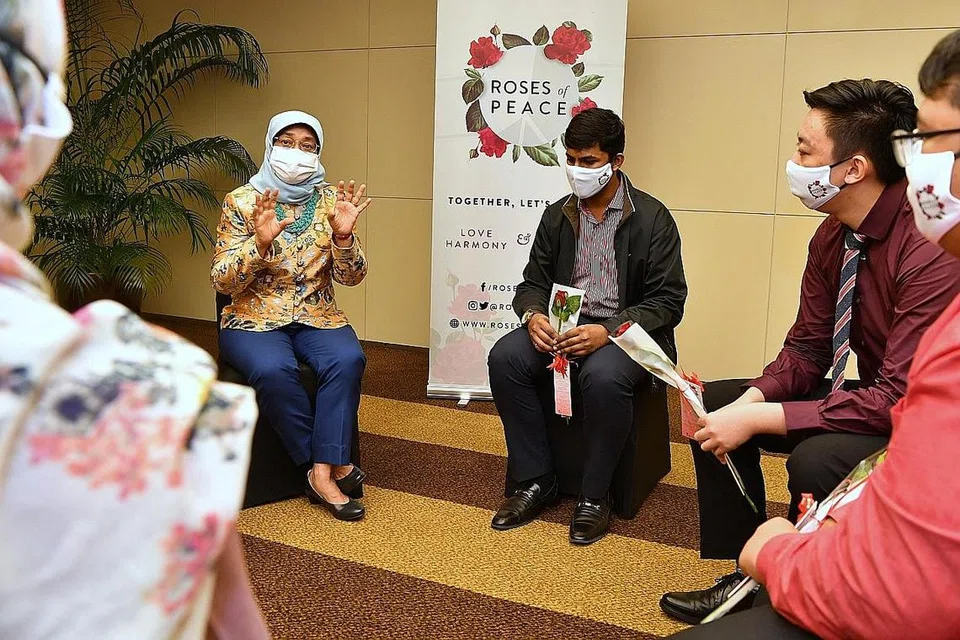 SEBAR MESEJ KEAMANAN: Presiden Halimah Yacob (kiri) berinteraksi bersama kumpulan Duta Keamanan yang dilantik sebagai sebahagian daripada Program Duta Roses of Peace 2021 dalam satu majlis yang diadakan di Hotel Amara semalam. - Foto BH oleh CHONG JUN LIANG