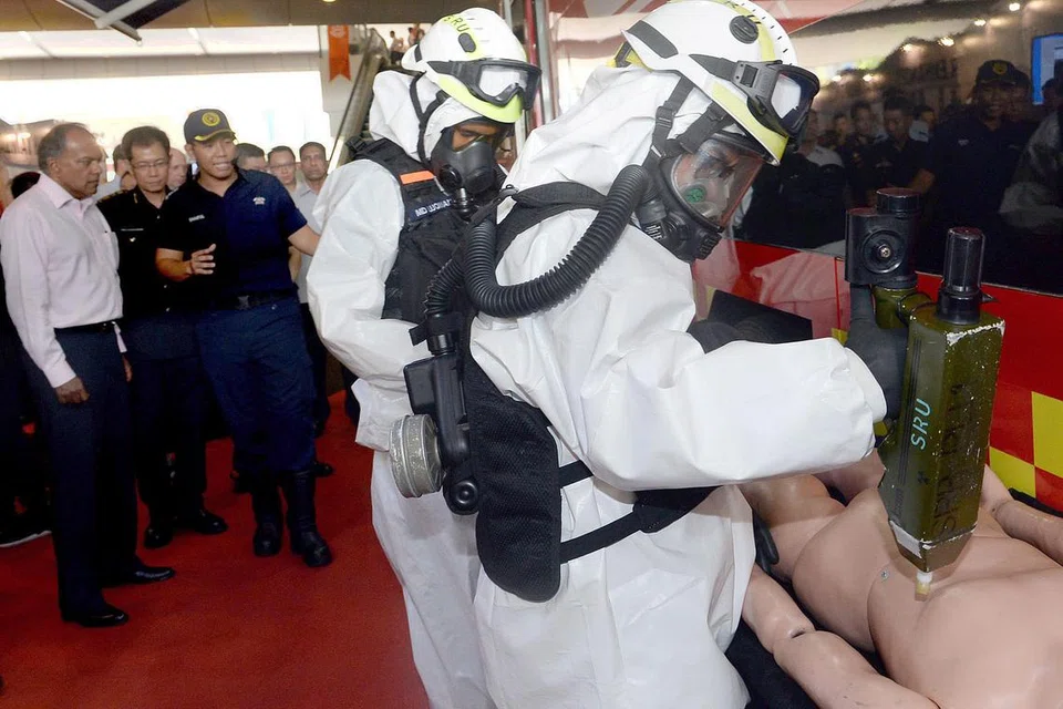 PEMBAHARUAN KEPADA KENDERAAN DEKONTAMINASI: Encik Shanmugam (kiri) menyaksikan pegawai SCDF melakukan demonstrasi menggunakan Kenderaan Dekontaminasi Massa (MDV) yang merupakan satu pembaharuan daripada Kenderaan Dekontaminasi Kakitangan (PDV) yang digunakan sebelum ini. Dalam masa sejam, MDV boleh mendekontaminasikan 20 mangsa terbaring dan 120 mangsa yang masih mampu berjalan apabila mereka terdedah kepada bahan berbahaya (HazMat). - Foto TAUFIK A. KADER