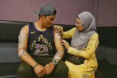 Cik Eriyana Subadi memeriksa krim kebas yang telah disapukan kepada tatu suaminya, Encik Jojo Sanchez Arriesgado, sementara menunggu sesi rawatan laser untuk menghapuskan tatu. 