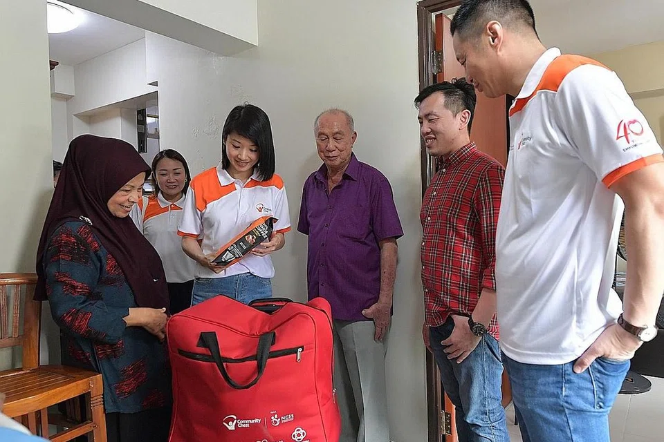 HULUR BANTUAN: Cik Rohani Rajab, 68 tahun, menerima habuan Fu Dai Community Chest daripada Cik Sun Xueling, yang diiringi Encik Loh; Dr Don Chen, Pengarah (Pendidikan dan Pembangunan Perniagaan) G.H.Y Culture & Media (Singapore) Ltd, dan Encik Danny Koh, pengerusi bersama jawatankuasa Fu Dai Community Chest 2023, di flatnya di Punggol semalam. - Foto BM oleh ALPHONSUS CHERN