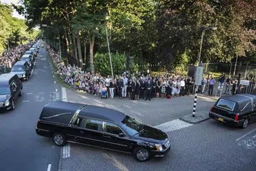 PERJALANAN PILU: Konvoi kereta membawa jenazah mangsa pesawat MH17 tiba di Korporaal van Oudheusden Kazerne, Belanda di mana ribuan penduduk menunggu di tepian jalan raya untuk memberi penghormatan terakhir. - Foto AFP