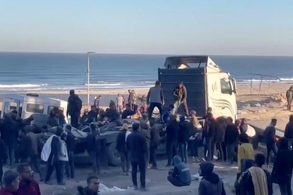 Rakyat Palestin mengangkat mangsa yang cedera dan maut dalam kejadian yang menurut pegawai kesihatan Palestin adalah tembakan tentera Israel ke atas penduduk yang sedang menunggu bantuan di Bandar Gaza, pada 29 Februari.