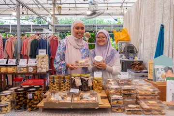 Bagi membezakan perniagaannya daripada perniagaan dari rumah lain, pengasas My Kids Craving, Cik Sri Rafizah Abdul Razak (kiri), secara berkala membuka gerai ‘pop-up’ di pelbagai lokasi. Pada Ramadan, beliau sering dibantu adiknya, Cik Nurfathiyatul Farhani (kanan).