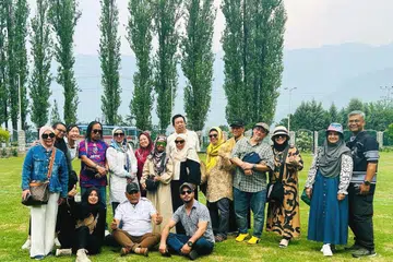Cik Rafeeda Mohammad Hussein (duduk, berpakaian hitam) dan suami, Encik Manzoor Ahmad Wangnoo (duduk, kanan) bergambar dengan sekumpulan pelancong warga Singapura yang dibawa mereka dalam percutian di Kashmir. 