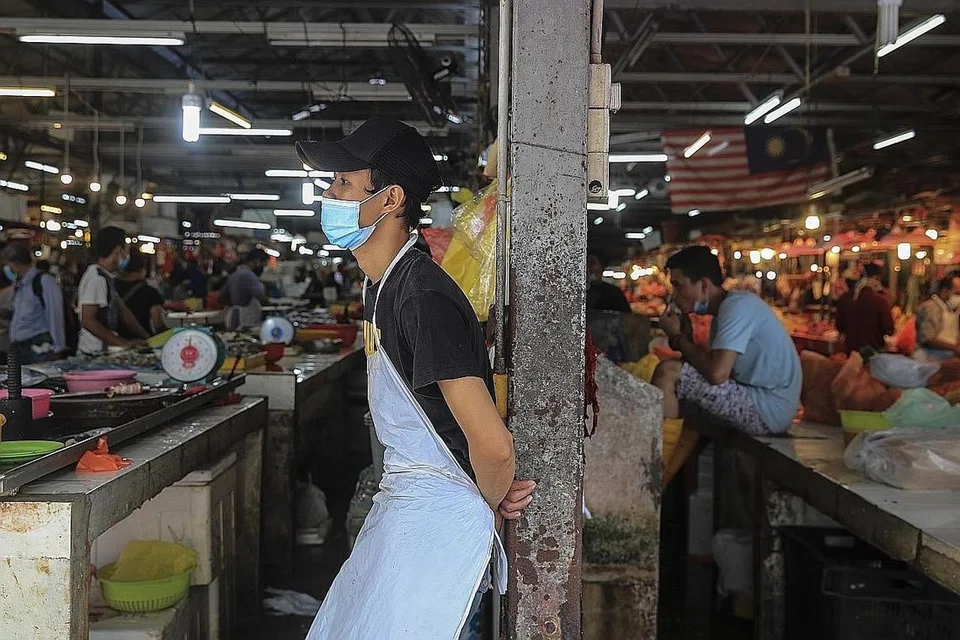 TUNGGU PELANGGAN: Seorang pegerai yang memakai pelitup menanti pelanggan di pasar di Kuala Lumpur. Malaysia menjadi negara tertinggi di Asia Tenggara bagi kes jangkitan koronavirus baru Covid-19. - Foto EPA-EFE