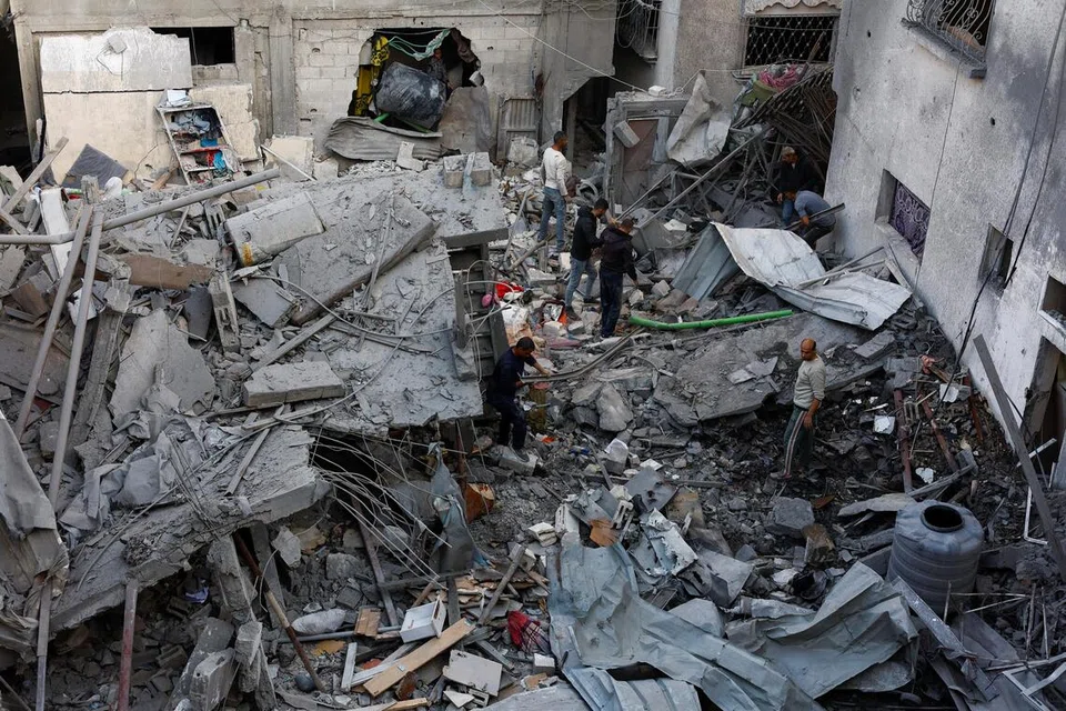 Para penduduk Palestin meninjau kerosakan selepas serangan udara Israel di Tengah Jaluran Gaza pada 23 November 2025.