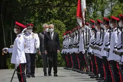 PERIKSA BARISAN KEHORMAT: Datuk Ismail Sabri, diiringi, Encik Lee memeriksa pasukan barisan kehormat di perkarangan Istana semalam.- Foto-foto BH oleh KEVIN LIM