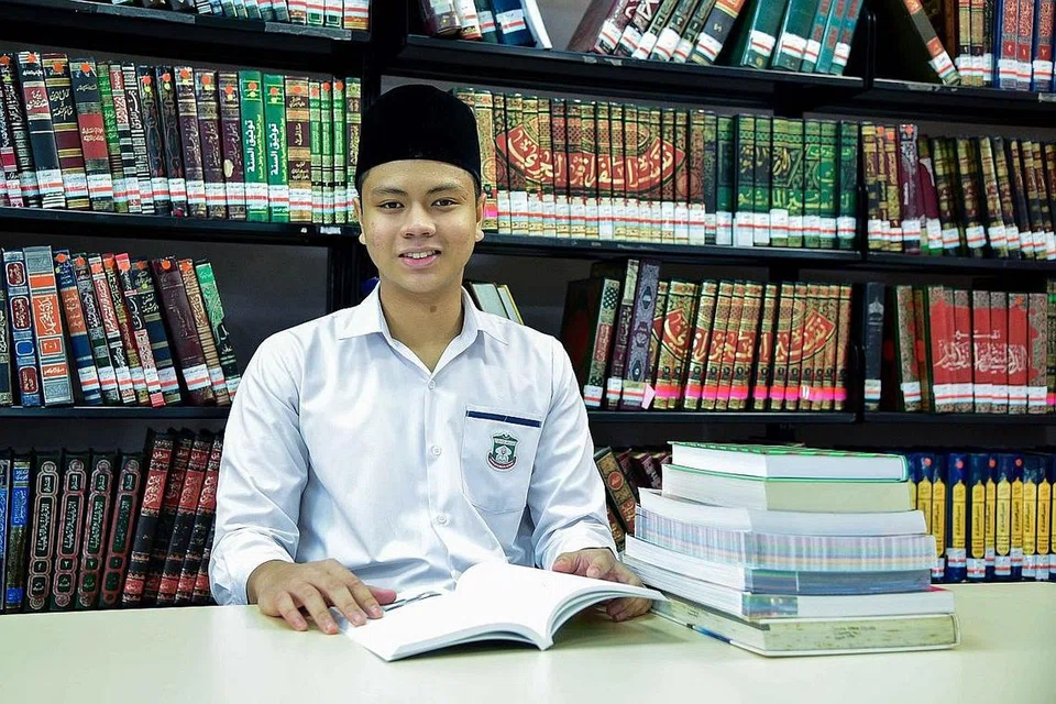 KEPUTUSAN AMAT MEMBERANGSANGKAN: Kohort pertama pelajar Program Diploma Baccaulaureate Antarabangsa (IBDP) Madrasah Aljunied Al-Islamiah menerima keputusan mereka semalam. Kesemua 25 pelajar itu lulus dan mencapai keputusan purata lebih tinggi berbanding keputusan global purata, dengan pelajar Pra-Universiti 2, Abdul Hakam Nor Razak (gambar atas), muncul pelajar terbaik kohort tersebut dengan mendapat 42 daripada keseluruhan 45 mata. - Foto MUIS