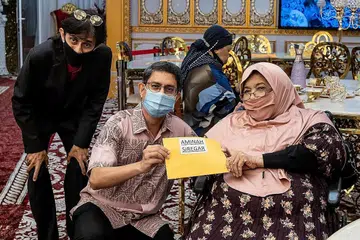 BANTUAN RINGANKAN BEBAN: Profesor Madya Dr Muhammad Faishal Ibrahim (tengah) memberi habuan $1,000 sebagai peruntukan Kempen Kami Peduli kepada mantan deejay Siti Aminah Siregar. Bersama mereka di kiri ialah pengurus Nazreen Catering, Syed Hafiz. - Foto BH oleh NUR DIYANA TAHA