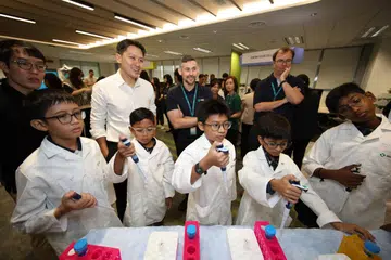 Murid-murid Sekolah Rendah Chua Chu Kang menggunakan peralatan di makmal bagi mengukur cecair.