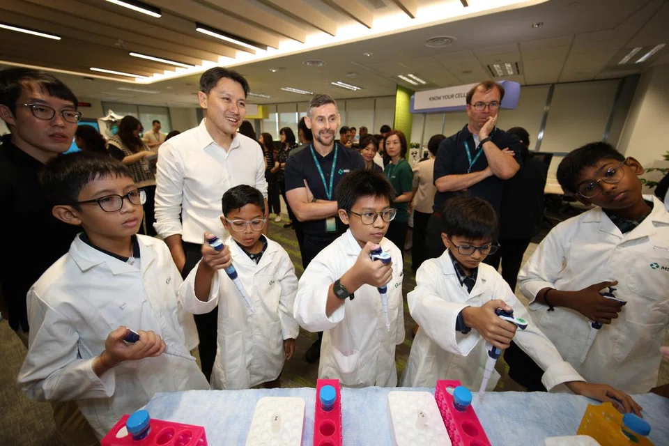 Murid-murid Sekolah Rendah Chua Chu Kang menggunakan peralatan di makmal bagi mengukur cecair.
