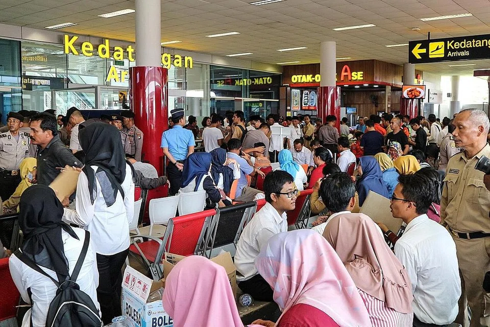 MASIH MENGHARAP: Keluarga serta sahabat handai mangsa penumpang (kiri) pesawat Lion Air JT610 berkumpul di Lapangan Terbang Depati Amir di Pangkal Pinang bagi menantikan berita terkini daripada pihak penyiasat. - Foto REUTERS
