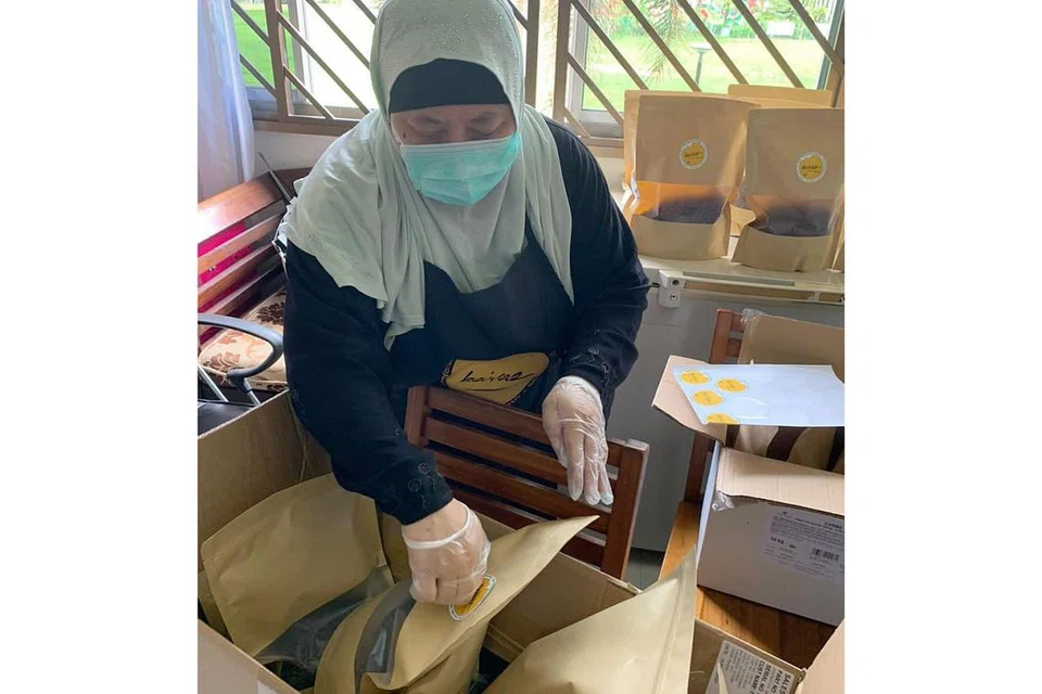 MAHU BANTU PENIAGA DARI RUMAH: Pemilik Heiraz Bakery, Cik Roszilah Md Nor, membungkus cip coklat yang dipesan orang ramai, termasuk peniaga kek dan kuih dari rumah, yang tidak dapat membeli bahan dari kedai kerana kehabisan stok. - Foto ihsan ROSZILAH MD NOR