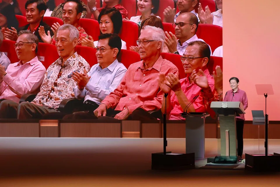 Dalam ucapan Rapat Hari Kebangsaan sulung beliau pada 18 Ogos, Perdana Menteri Lawrence Wong (di podium) memberi penghormatan kepada Menteri Kanan Lee Hsien Loong dan Menteri Kanan Emeritus  Goh Chok Tong (empat dan dua dari kanan pada skrin). Encik Wong turut melahirkan penghargaan kepada Perdana Menteri dan pemerintah terdahulu atas pencapaian Singapura sepanjang 60 tahun lalu.