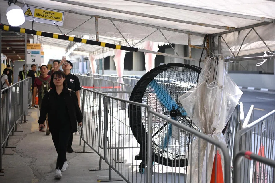 Penumpang beratur di tempat berteduh, sambil menunggu ketibaan bas ulang-alik S8 ke Expo pada hari pertama perkhidmatan kereta api Laluan Timur-Barat (EWL) antara stesen Tanah Merah dengan Expo digantung.