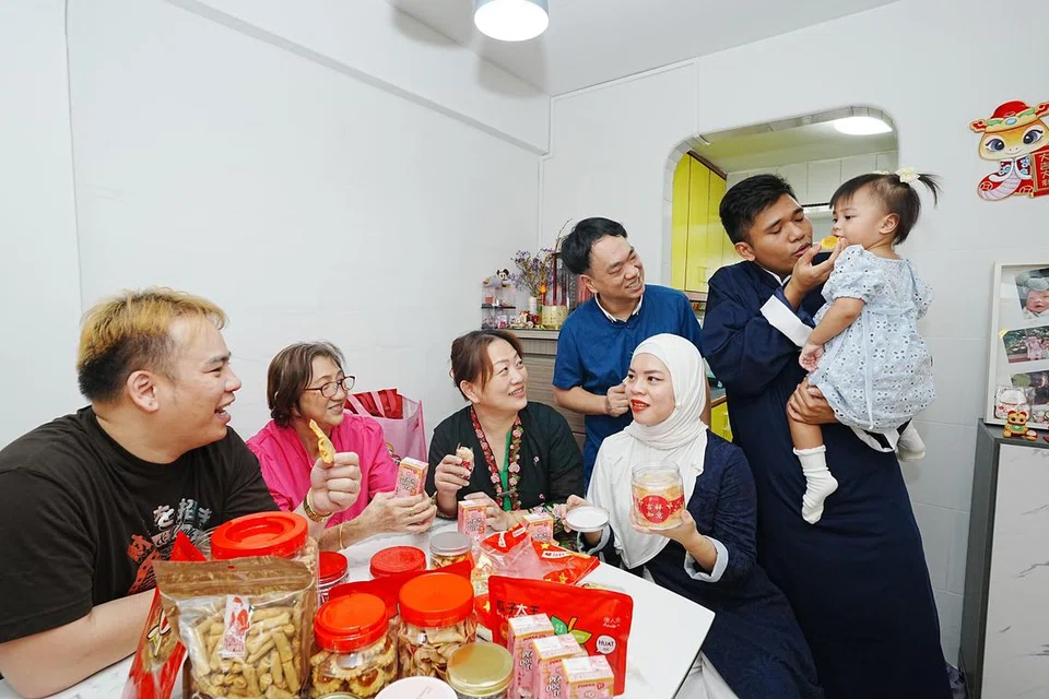 Cik Sharmin Loh (tiga dari kanan), bersama keluarganya, termasuk mak ciknya, Cik Susan Lim Siew Cheng (tiga dari kiri), menikmati hidangan kuih tradisional Cina. 
