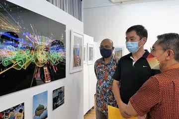 RAKAM KEINDAHAN GEYLANG SERAI: Dr Maliki (kanan) dan pemilik studio seni, Kamal Arts, Encik Kamal Dollah (kiri) menikmati gambar petikan Encik Encik Rodney Ee (tengah), yang juga dipilih sebegai pemenang Cabaran Foto InstaGeylang 2022. - Foto WISMA GEYLANG SERAI