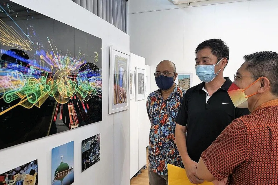 RAKAM KEINDAHAN GEYLANG SERAI: Dr Maliki (kanan) dan pemilik studio seni, Kamal Arts, Encik Kamal Dollah (kiri) menikmati gambar petikan Encik Encik Rodney Ee (tengah), yang juga dipilih sebegai pemenang Cabaran Foto InstaGeylang 2022. - Foto WISMA GEYLANG SERAI